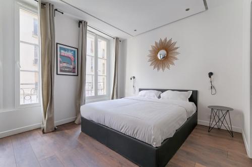 une chambre blanche avec un lit et une fenêtre dans l'établissement TBS 307 - Superb studio in the heart of Paris, à Paris