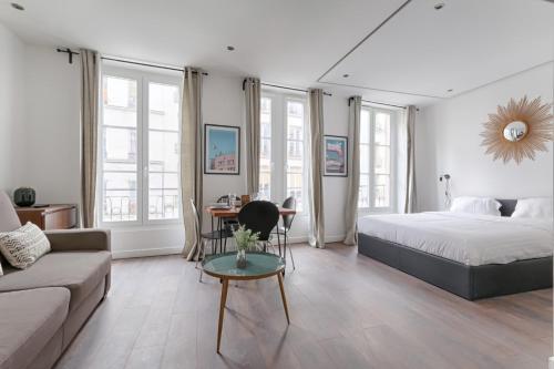 une chambre avec un lit, une table et un canapé dans l'établissement TBS 307 - Superb studio in the heart of Paris, à Paris