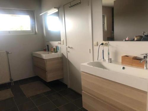 a bathroom with a sink and a mirror at La maison noire au coin in Bruges