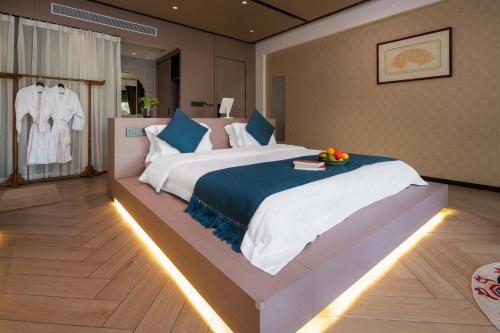 a large bedroom with a large bed with blue pillows at Yun Guan Shunde Renjia Resort Hotel in Jinghong