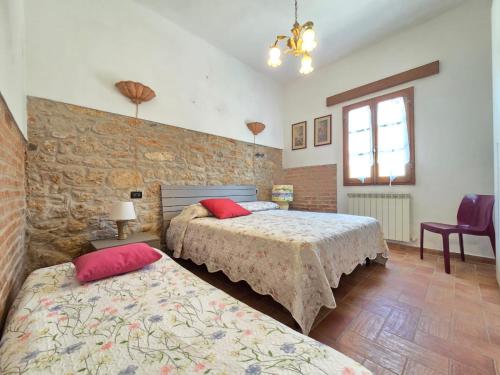 a bedroom with two beds and a brick wall at Appartamento Margarita Maris - 20mt dalla Spiaggia in Follonica
