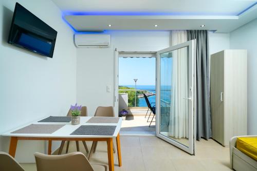 a living room with a table and a view of the ocean at Tarsa's House by the Sea in Skala Marion