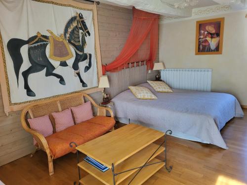 a bedroom with two beds and a bench and a horse painting at Clos St Ange (Dinan-St Malo) in Vildé-Guingalan