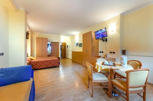 a living room with a table and a room with a bed at Hotel Garni Le Corti in Grosotto