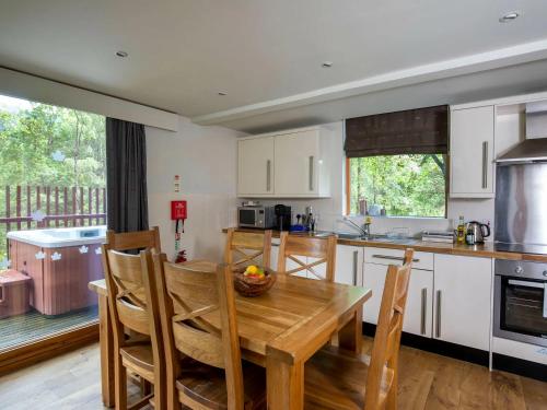 a kitchen with a wooden table and some chairs at Strathyre, Ben Ledi Cabins - Forest Holidays in Callander