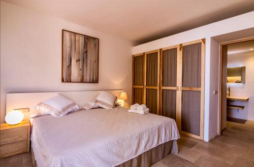 a bedroom with a large bed with white sheets and pillows at Apartamento Villa Cabrera in Colònia De Sant Jordi