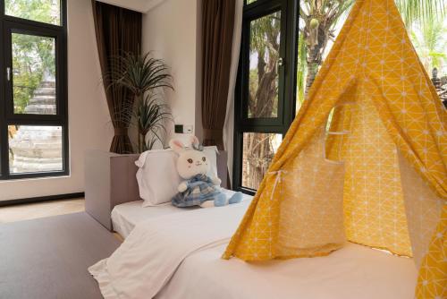 a bedroom with a bed with a teepee at Yun Guan Shunde Renjia Resort Hotel in Jinghong
