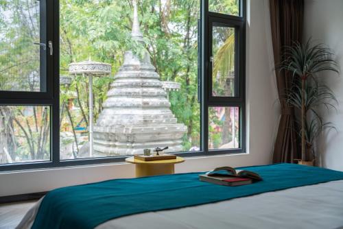 a bedroom with a bed and a view of a temple at Yun Guan Shunde Renjia Resort Hotel in Jinghong