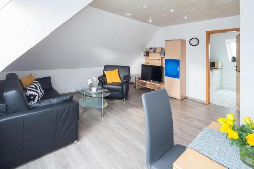 a living room with a couch and chairs and a table at Mayglück App 3 in Norderney