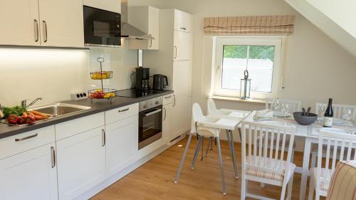 a kitchen with white cabinets and a counter top at Dreschdiele - Landlust Osterwarf in Norddeich