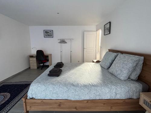 a bedroom with a bed and a desk and a chair at La brise marine apt rdc maison cour fermée parking et terrasse à 800 m plage Omaha beach avec table de ping pong proche Port en Bessin in Vierville-sur-Mer