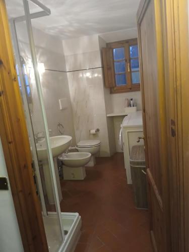 a small bathroom with a toilet and a sink at Olive Tree Apartment in Impruneta