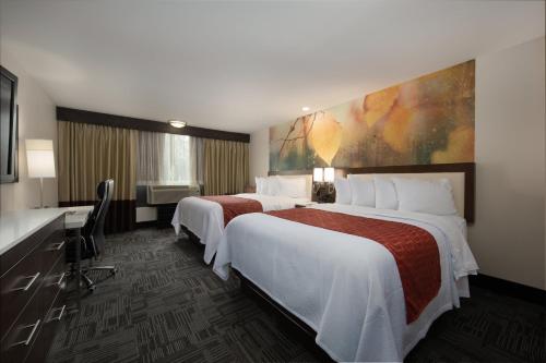 a hotel room with two beds and a desk at Holiday Inn Brookfield - Milwaukee by IHG in Brookfield