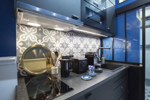 - un comptoir de cuisine avec un évier et un miroir dans l'établissement Le Café des Invalides, à Paris