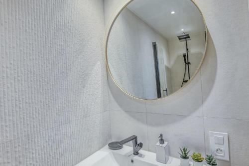 une salle de bain blanche avec un miroir et un lavabo dans l'établissement Centre-ville – Appartement (A/C) 6 personnes – 5 minutes plages et gare by Weekome, à Antibes