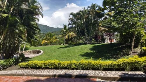 a park with palm trees and a green lawn at ATENEA SPA Hotel in Villeta