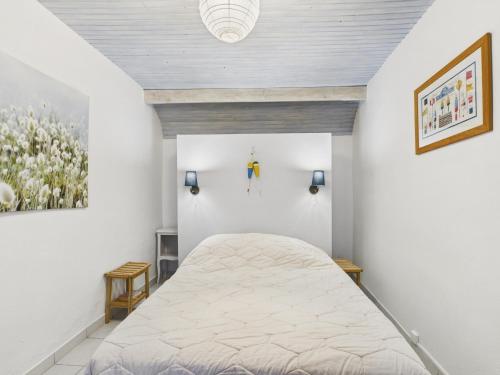 a bedroom with a bed and a painting on the wall at Charmante maison en pierre - vue sur l'océan in Lilia
