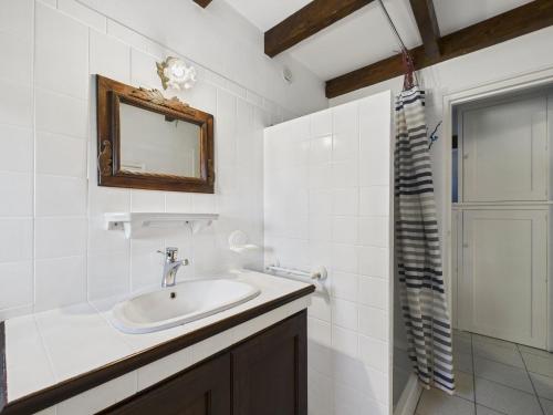 a bathroom with a sink and a mirror and a shower at Charmante maison en pierre - vue sur l'océan in Lilia