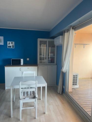 une salle à manger avec des murs bleus, une table et une chaise dans l'établissement Studio vue mer proche monaco, à Beausoleil