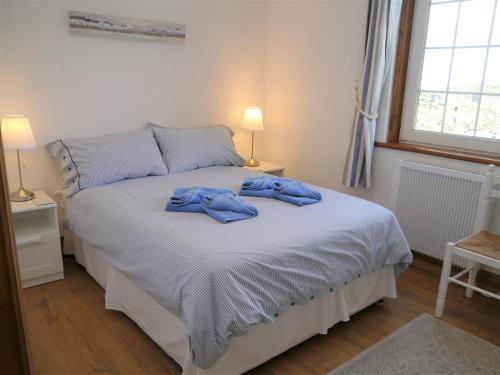 a bedroom with a bed with blue towels on it at Primrose Cottage in Rockcliffe