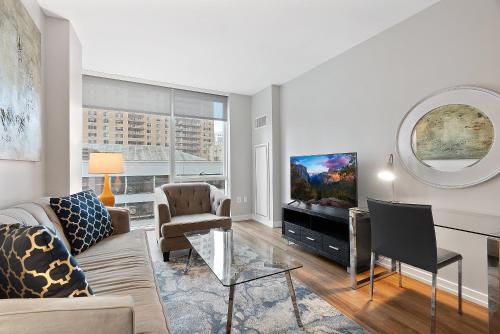 a living room with a couch and a tv at Global Luxury Suites at Brookline Village in Brookline