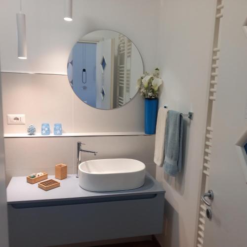 a bathroom with a white sink and a mirror at B&B Villa Letizia in Castelbuono