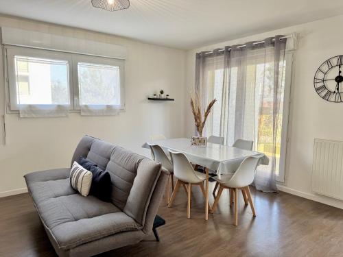 un salon avec un canapé et une table dans l'établissement Le Gregorien, Centre de Saint Gregoire, à Saint-Grégoire