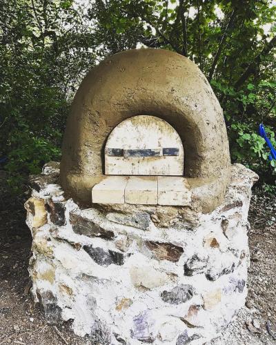 an old stone oven sitting on the ground at Lickham Bottom Camping in Hemyock
