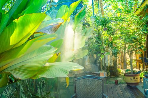 a patio with plants and a chair in a garden at Yun Guan Shunde Renjia Resort Hotel in Jinghong