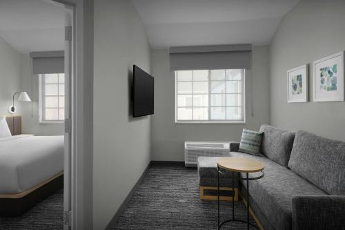 a hotel room with a bed and a couch and a table at TownePlace Suites by Marriott Annapolis in Annapolis