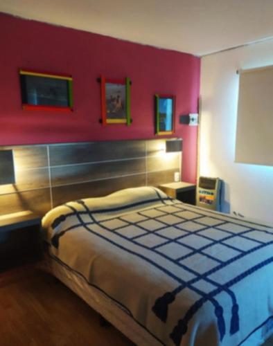 a bedroom with a large bed with a red wall at Casa de mar in Miramar