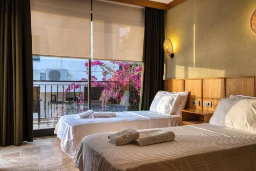 a hotel room with two beds and a window at Captivating Casa La Calypso in Kas