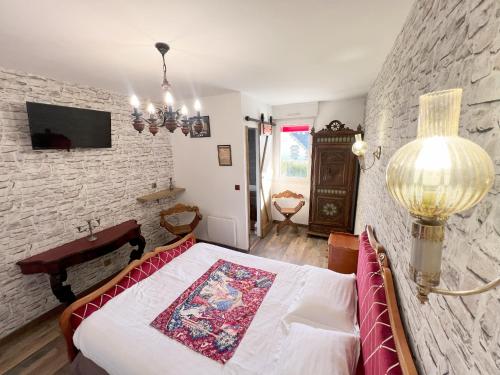 ein Schlafzimmer mit einem Bett und einer Steinwand in der Unterkunft Cap'tain Cook in Caurel