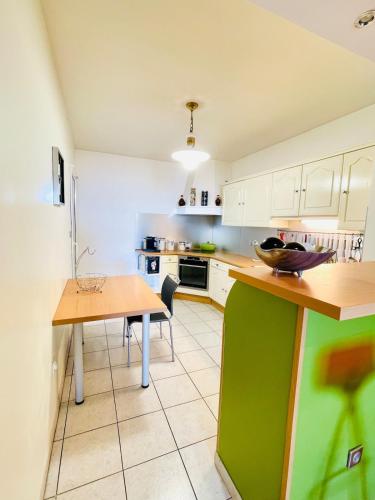 une cuisine avec des placards blancs et un comptoir vert dans l'établissement Ajaccio sanguinaires F3, à Ajaccio