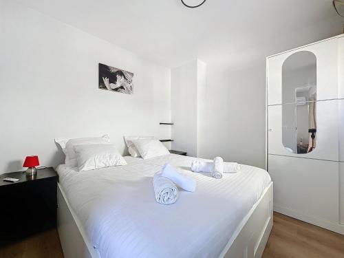 - une chambre blanche avec un lit blanc et des serviettes dans l'établissement Intuition 4pers 10min Palais, à Cannes