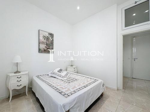 - une chambre blanche avec un lit et une table de nuit dans l'établissement Intuition - 3BR - 10min Palais, à Cannes