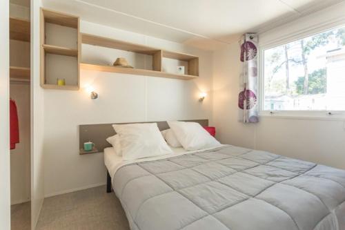 Un dormitorio con una cama grande y una ventana. en Camping La Pointe Saint-Gildas - Maeva, en Préfailles