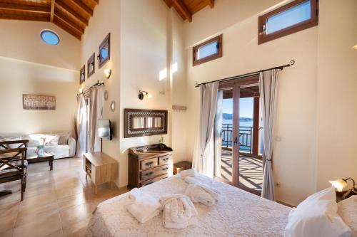 een slaapkamer met een groot bed en een balkon bij Yasemi by Vintage Travel in Sivota