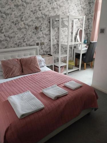 a bedroom with a bed with two towels on it at Delamere Hotel in Blackpool