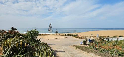a road leading to a beach next to the ocean at Villa vue mer imprenable- charme et tranquillité in Sidi Boulfdail