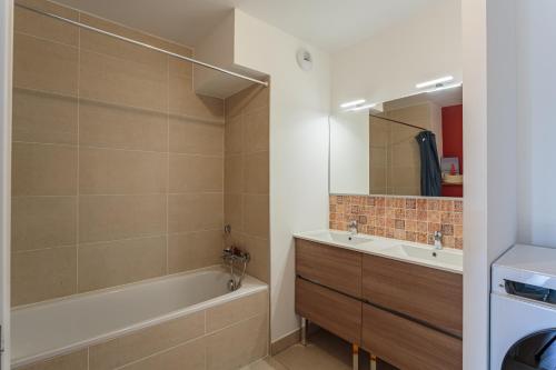 une salle de bain avec une baignoire et un lavabo dans l'établissement DUNA Bel appartement lumineux avec rooftop et jacuzzi, à Anglet