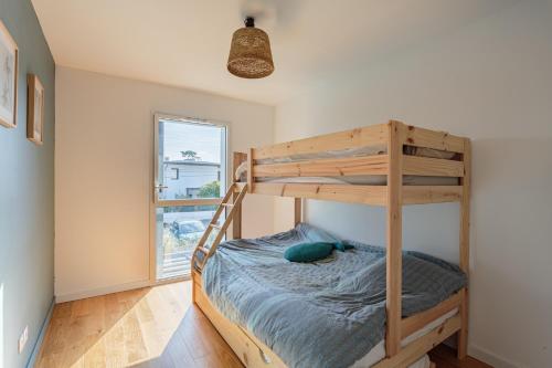 une chambre avec un lit superposé et une fenêtre dans l'établissement DUNA Bel appartement lumineux avec rooftop et jacuzzi, à Anglet