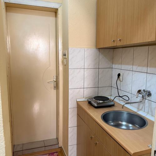 a small kitchen with a sink and a door at Accommodation Nedeski in Ohrid