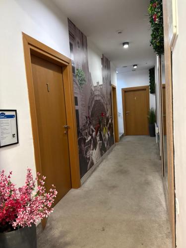 a corridor of a hallway with doors and flowers at Deluxe Nortel Hotel in Sarajevo