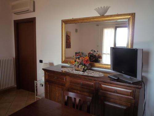a dresser with a mirror and a television on it at Saturnia Tuscany Country House in Saturnia