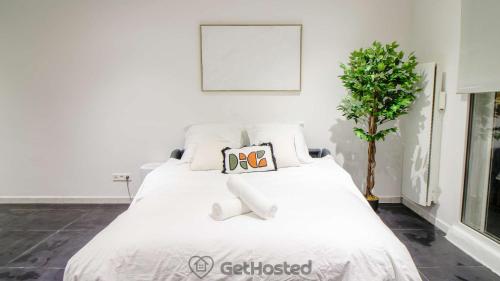 a white bed with a pillow on top of it at La Villette - Gorgeous Flat in Pantin - GetHosted in Pantin