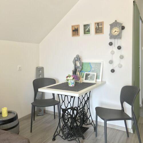 a table with chairs and a laptop on it in a room at Futrinka Vendégház in Baja