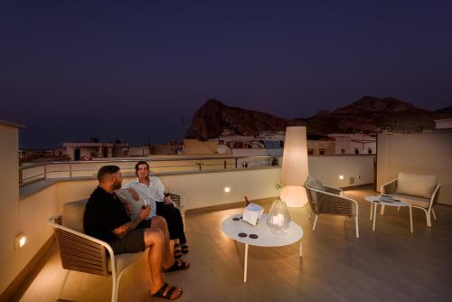 two people sitting on a balcony at night at Bedda Luna B&B in San Vito lo Capo