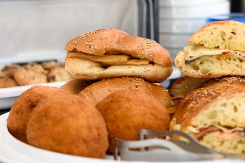 a pile of sandwiches and pastries on a plate at Bedda Luna B&B in San Vito lo Capo
