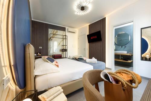 a hotel room with a bed and a chair at Bedda Luna B&B in San Vito lo Capo